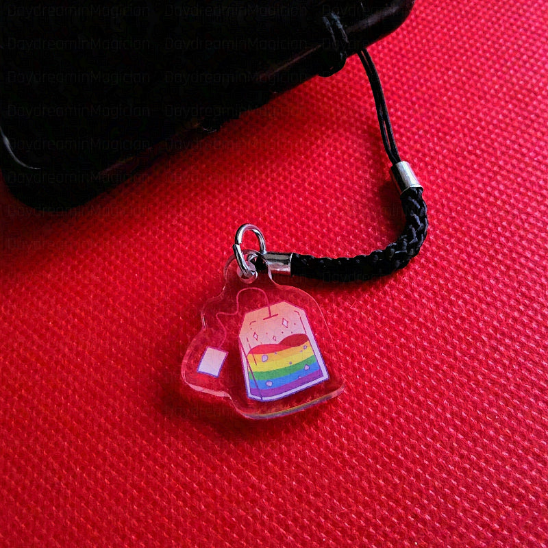Phone charm with rainbow design on a red surface