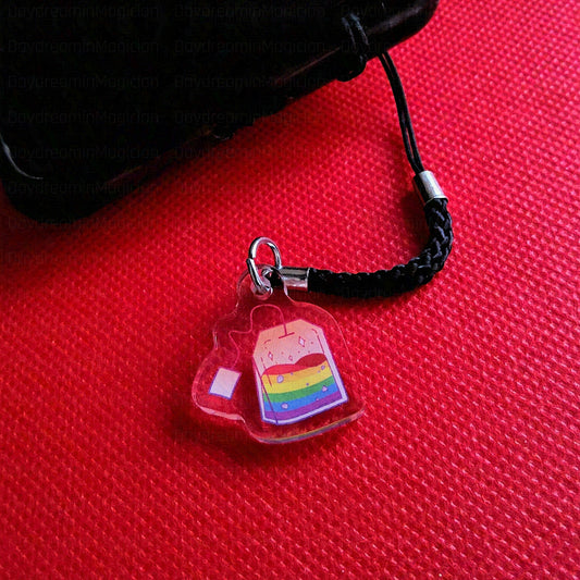 Phone charm with rainbow design on a red surface